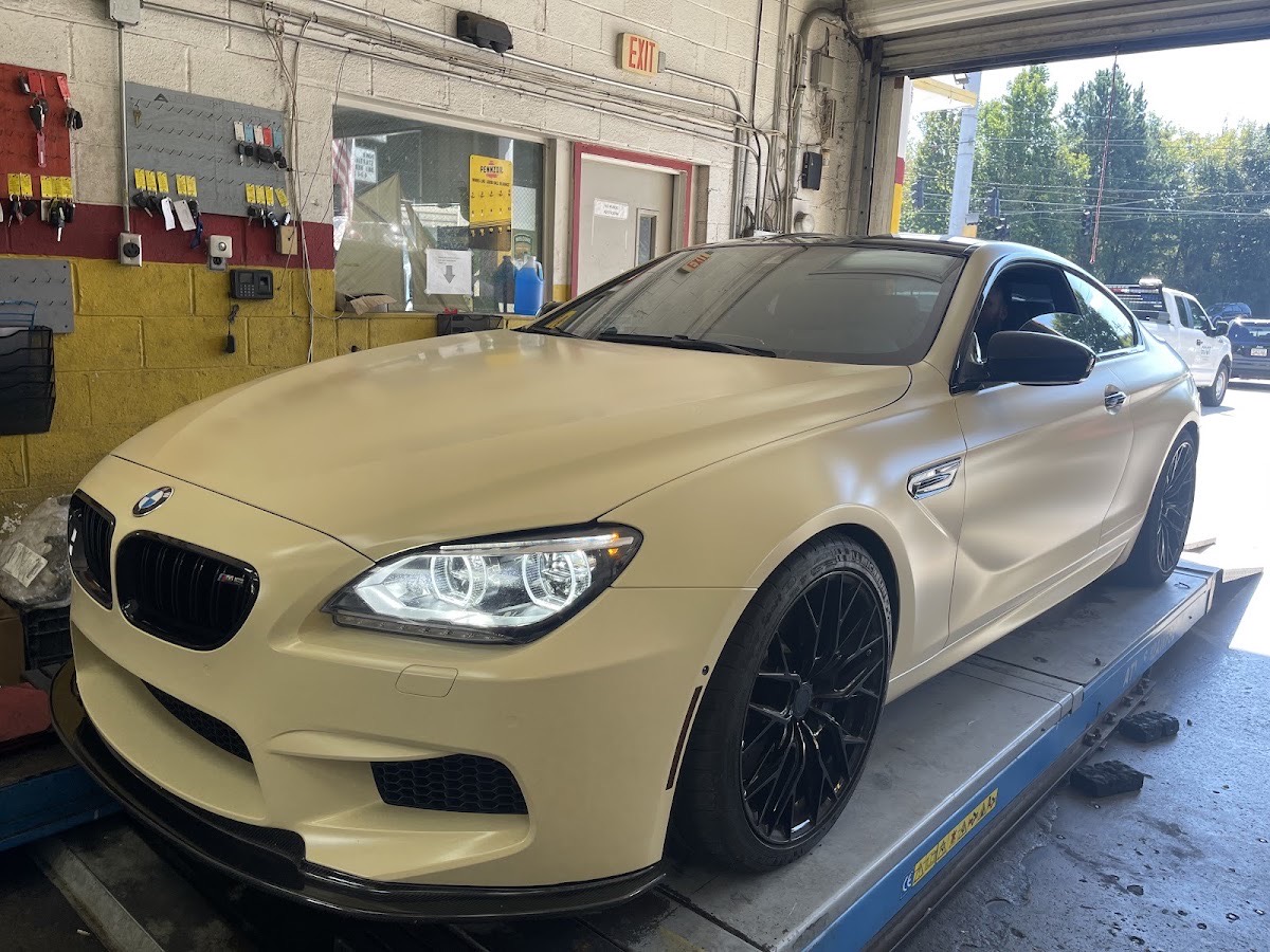 A vehicle on the service rack inside the Car Care One bay
