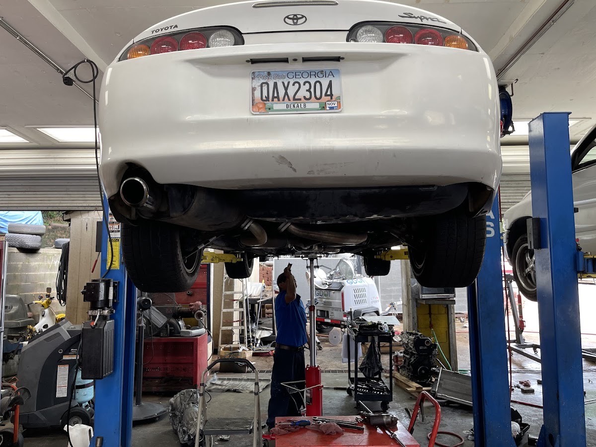 A car up on the lift at Car Care One with a technician working on the exhaust underneath