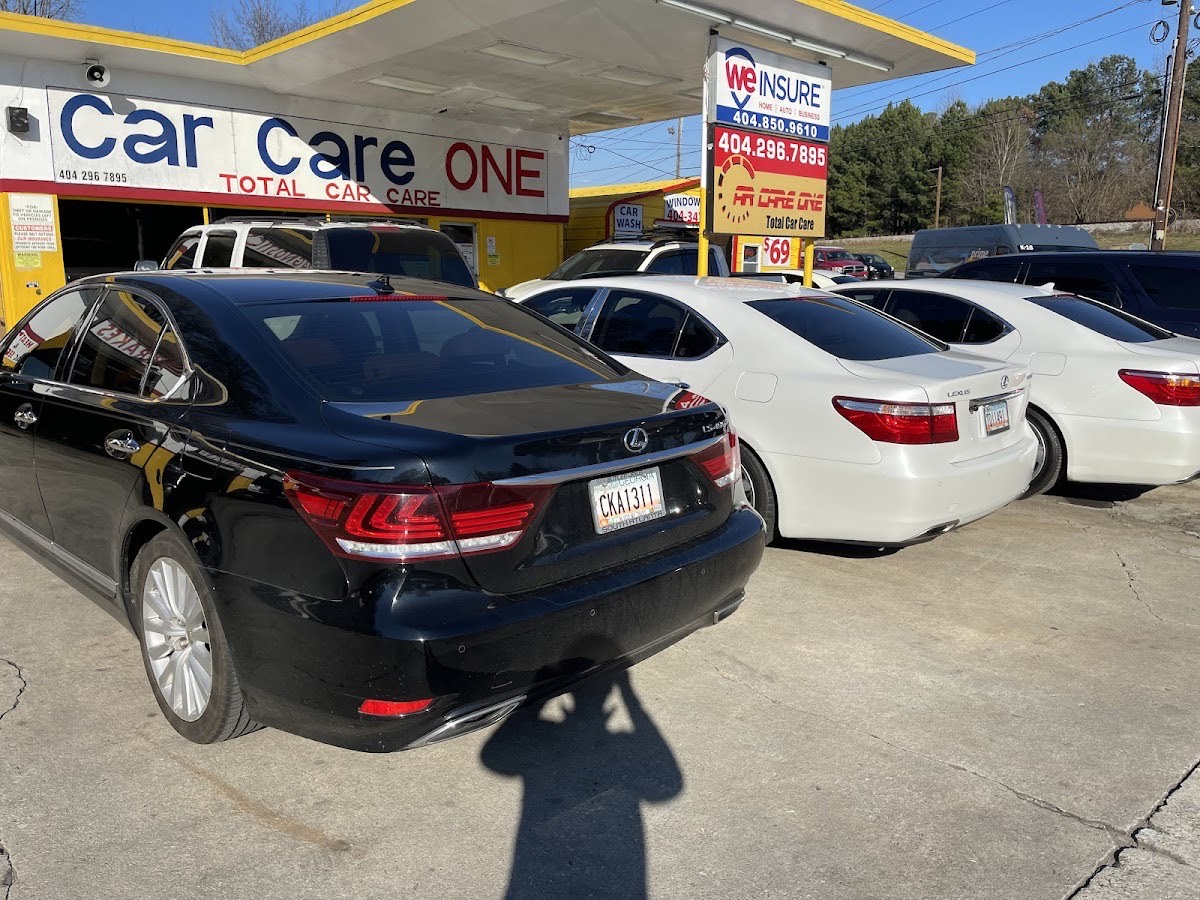 The Car Care One storefront on E Ponce de Leon Ave with customer cars out front